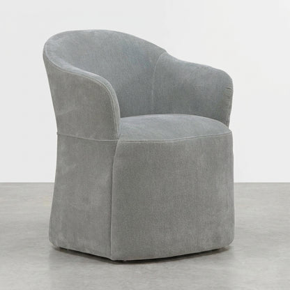 Grey upholstered swivel chair on a smooth concrete floor.