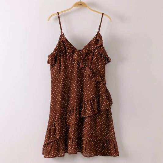 Brown polka dot dress with ruffled layers on a hanger.