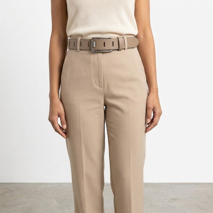 Woman wearing beige pants with a matching belt.