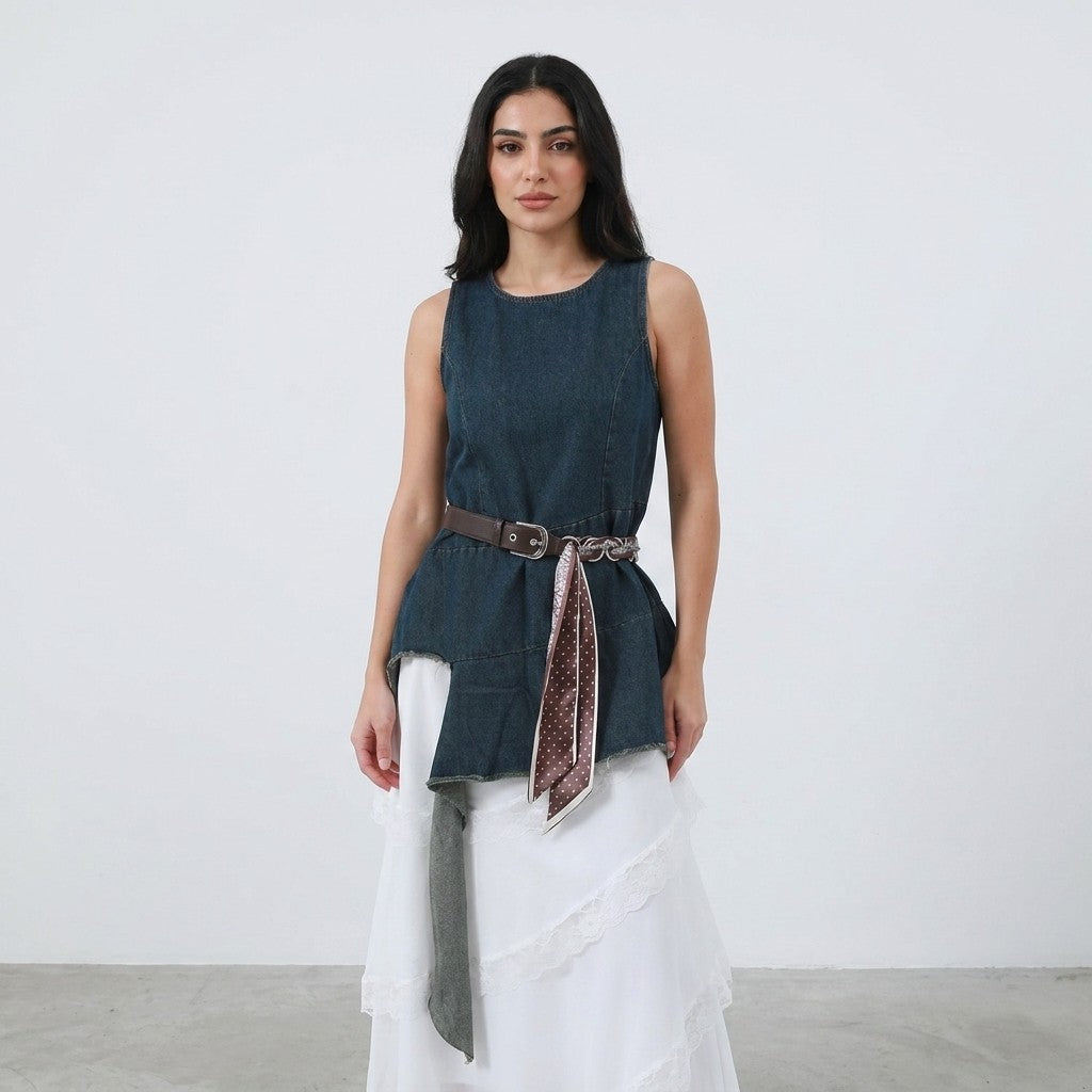 Woman in blue sleeveless top, white skirt, and belt with scarf.