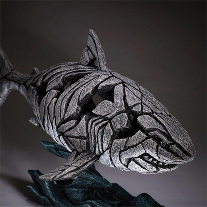 Stone sculpture of a shark with abstract fragmented design.