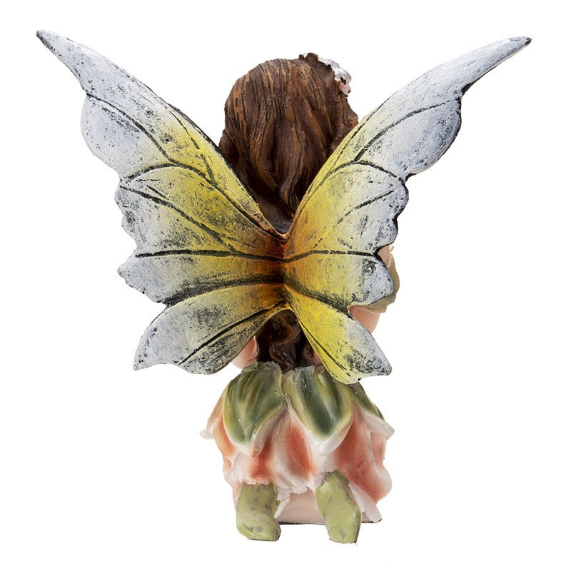 A fairy figurine with yellow wings perched on a flower.