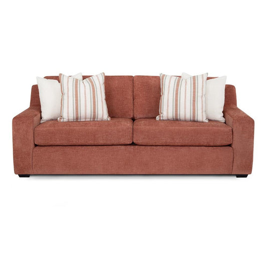 Rust-colored sofa with striped and white pillows.