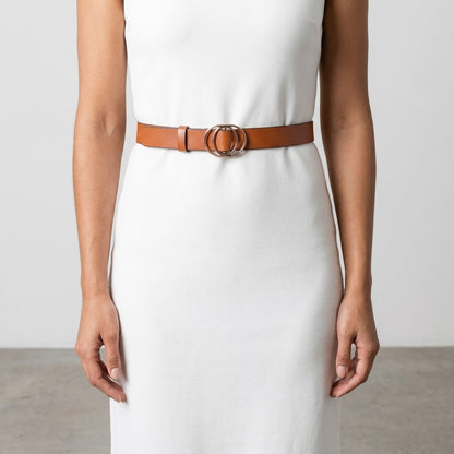 Woman in white dress with a brown belt featuring a double circle buckle.