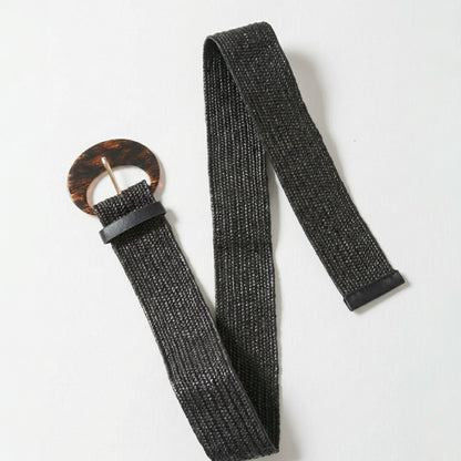 Black woven belt with a round, tortoiseshell-style buckle.
