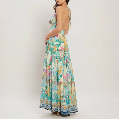 Woman in a vibrant, backless floral maxi dress, side view.
