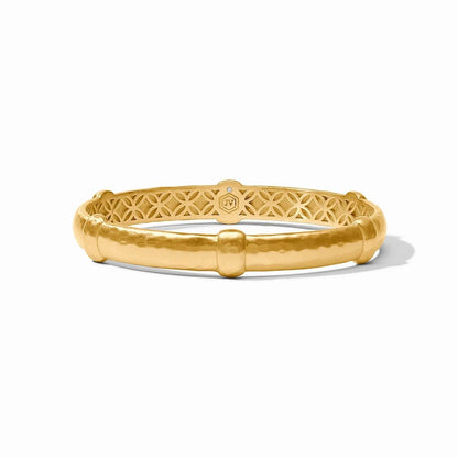 A gold bangle bracelet with an intricate openwork pattern, displayed on a white background.