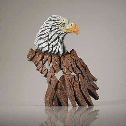 Wooden eagle sculpture with detailed carved wings and a textured head.