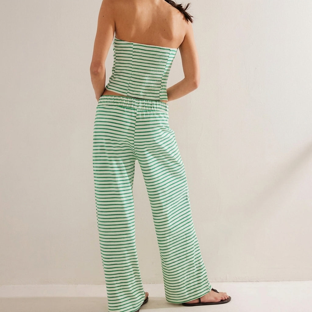 Person in striped green outfit, facing away, on light background.