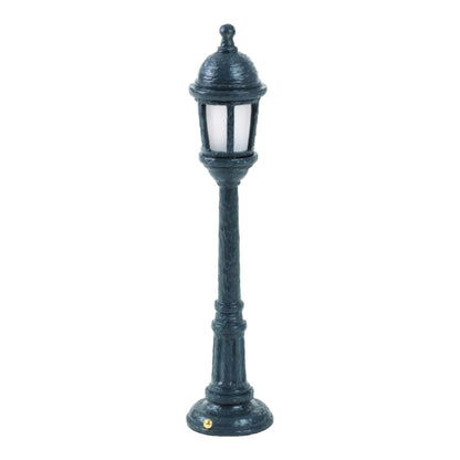Miniature vintage-style lamp post on a white background.
