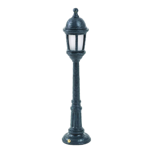 Miniature vintage-style lamp post on a white background.