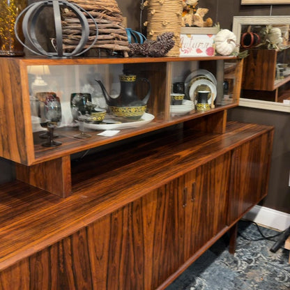 Mid-century hutch with dishes and autumn decor.