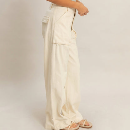 Wide-legged beige pants with pocket detail and sandals.