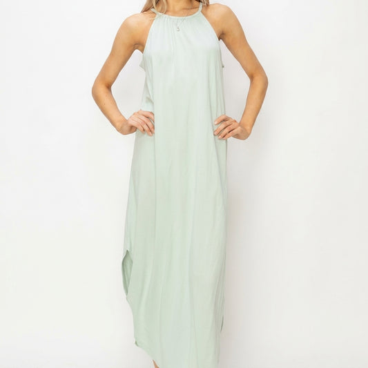 Person wearing a light green halter neck maxi dress against a white background.