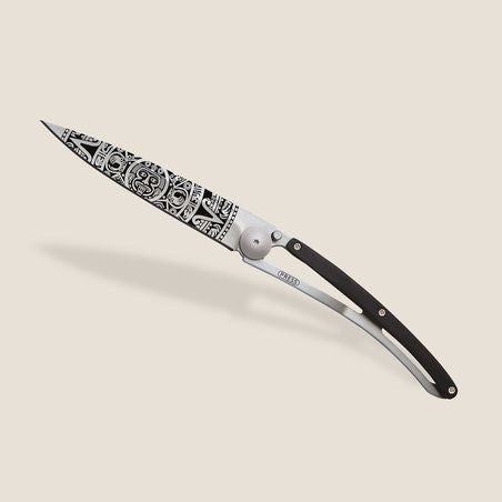 Ornate folding knife with intricate black patterns on the blade.