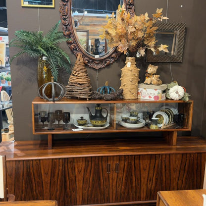 Wooden cabinet with autumn decor and vintage dishes on display.