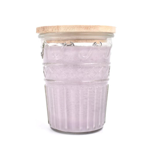 Purple candle in a glass jar with a wooden lid.