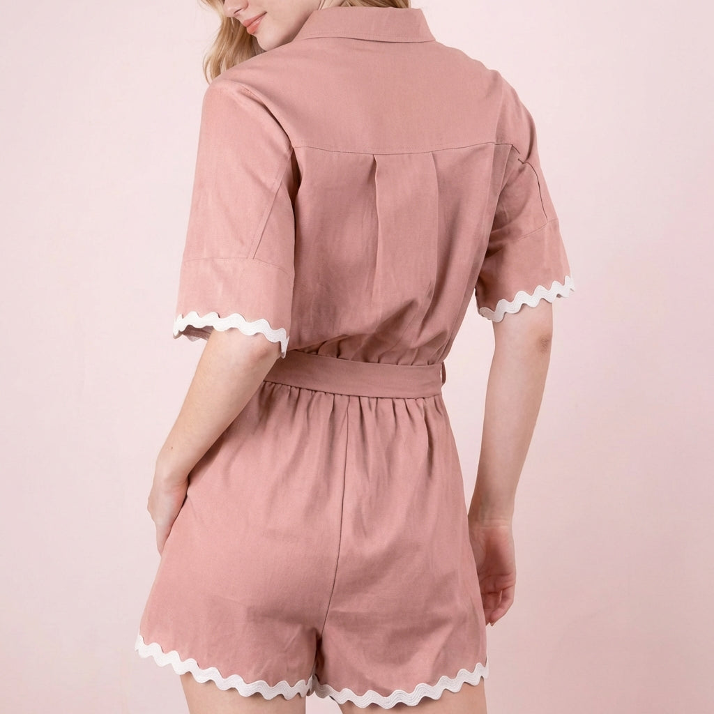 Woman in pink romper with white scalloped trim, facing away.