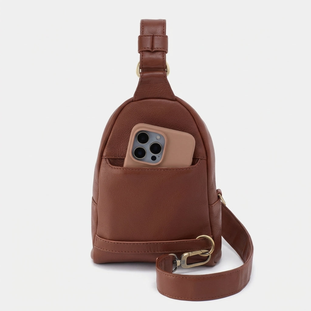 Brown leather bag with a phone in its pocket, against a plain white background.