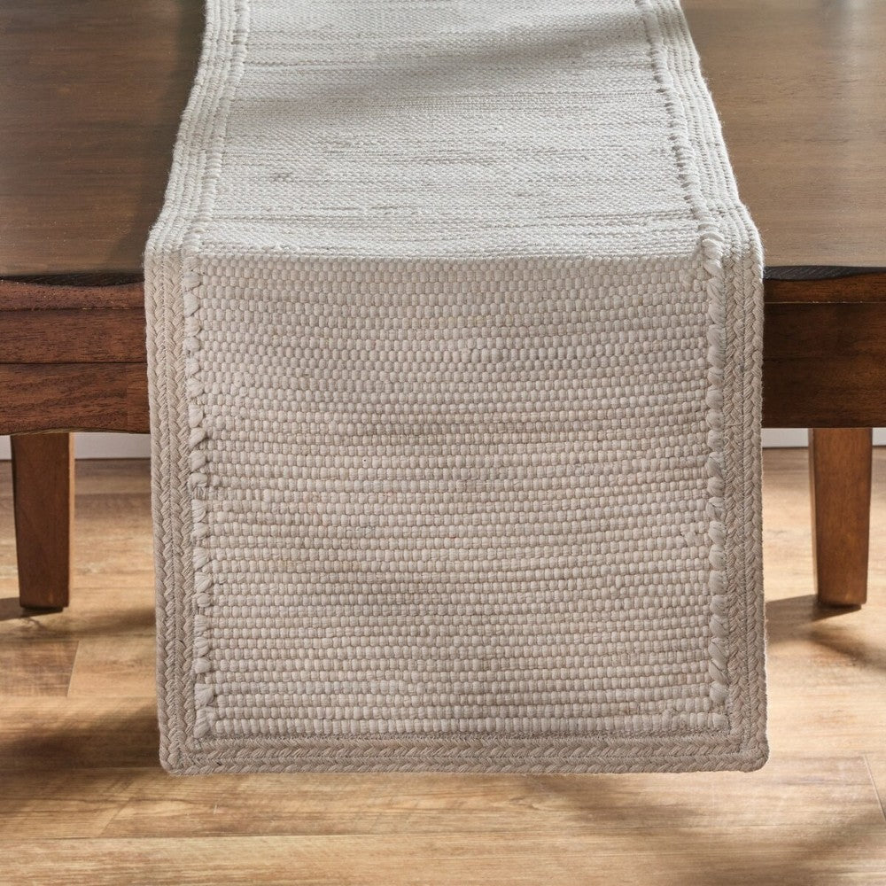 Woven beige table runner on a wooden table.