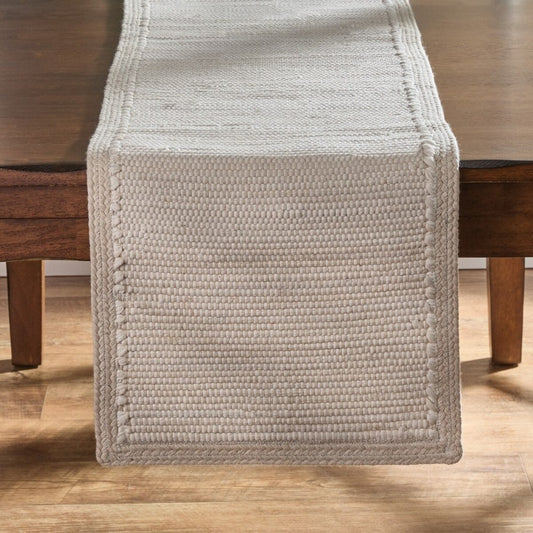 Woven beige table runner on a wooden table.