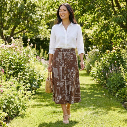 Brown patterned skirt, mid-length with floral designs, paired with heeled sandals.