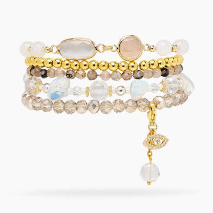Layered bracelets with beads and gem charms.