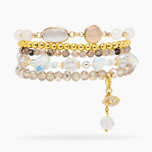 Layered bracelets with beads and gem charms.