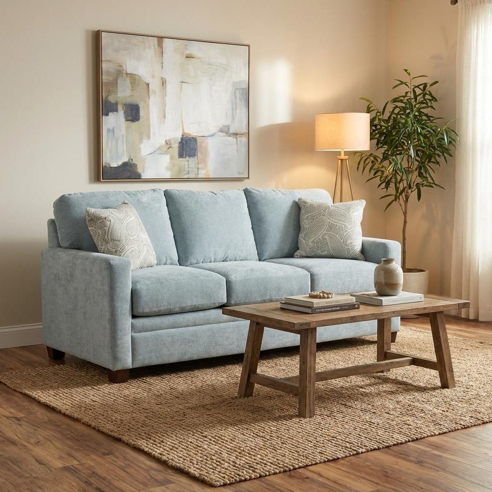 Cozy living room with blue sofa, wooden table, and abstract artwork.