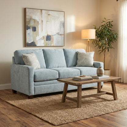 Cozy living room with blue sofa, wooden table, and abstract artwork.