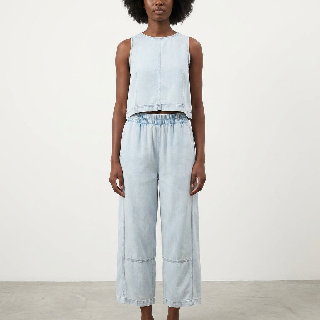 Person in light denim sleeveless top and wide-leg pants.