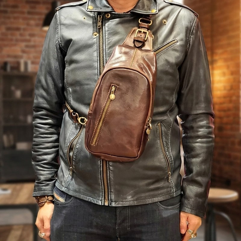Person wearing a leather jacket and brown leather crossbody bag.