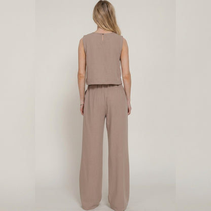 Woman in beige outfit facing away.