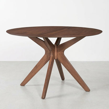 Round wooden table with modern geometric legs.