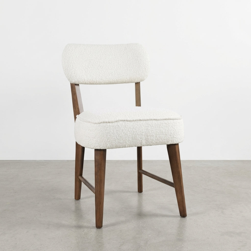 Modern chair with wooden legs and white upholstered seat and backrest.