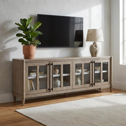 Wooden cabinet with a plant, lamp, and wall-mounted TV in a bright room.