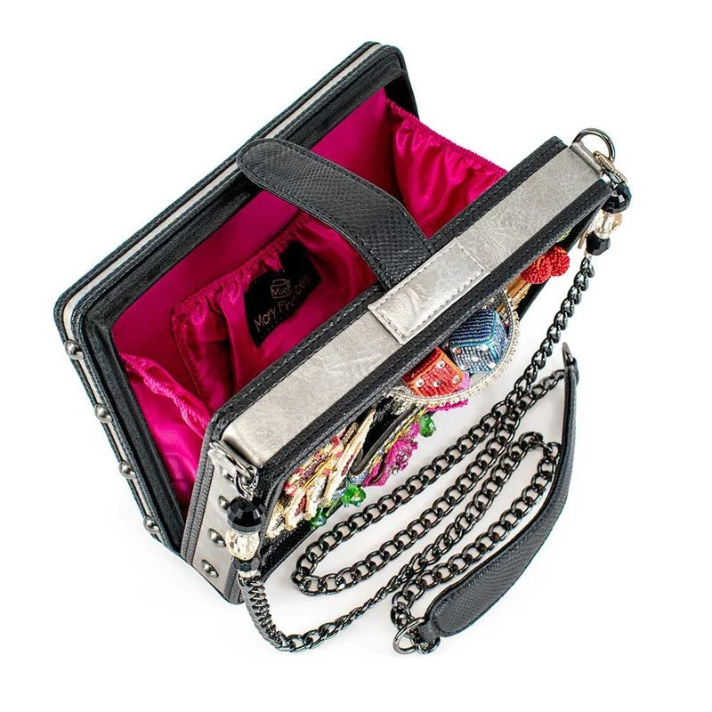 Ornate handbag with pink lining and chain strap, embellished with colorful beads.