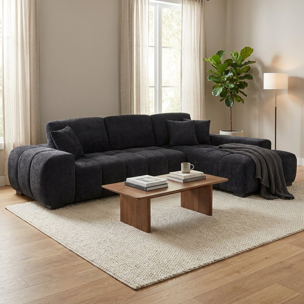 Cozy living room with dark sofa, wooden table, and large plant.