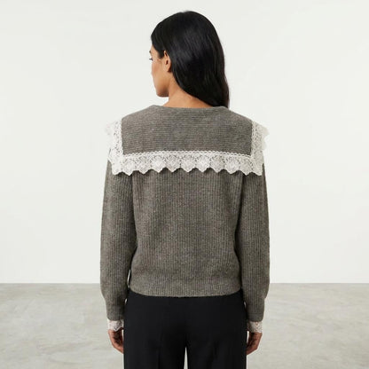 Woman facing away, wearing a gray sweater with lace details on the back.