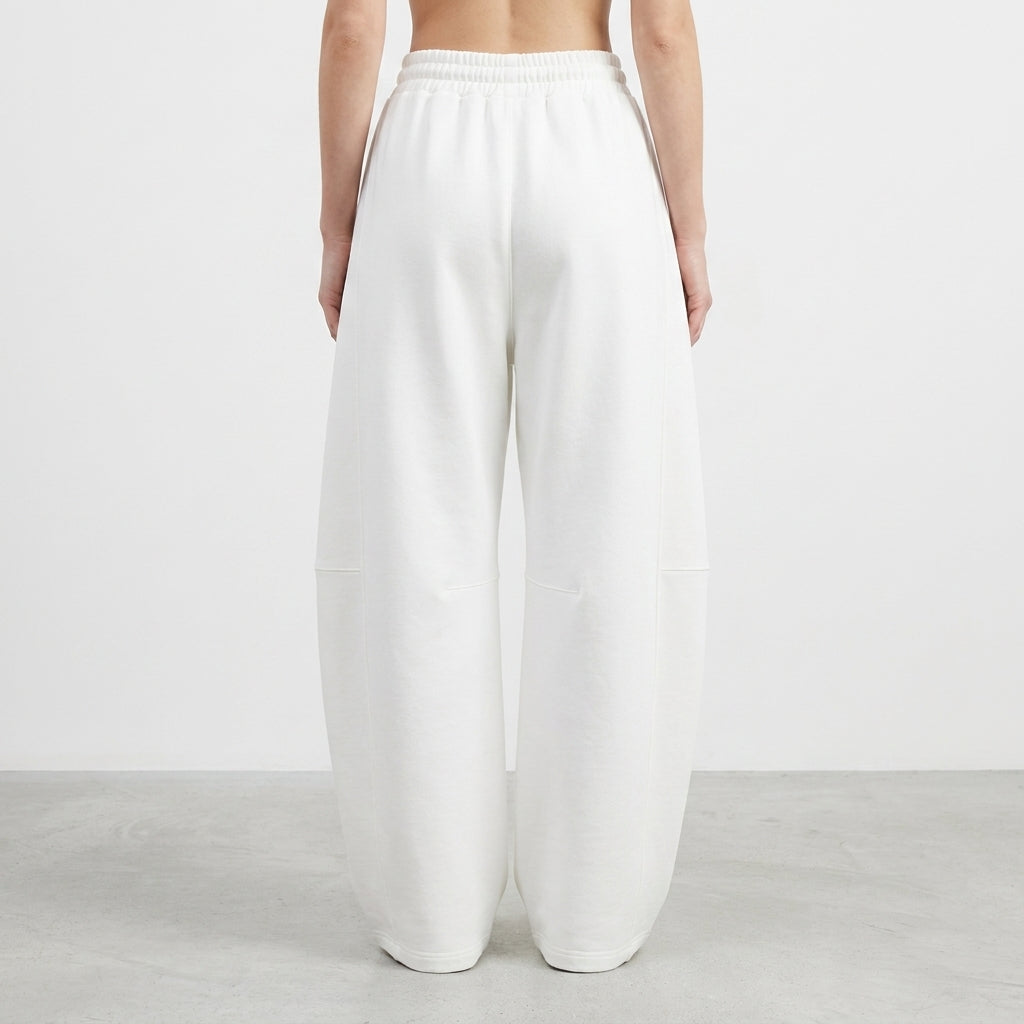 Person wearing loose white pants, back view.