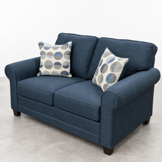 Blue loveseat with two circle-patterned pillows.