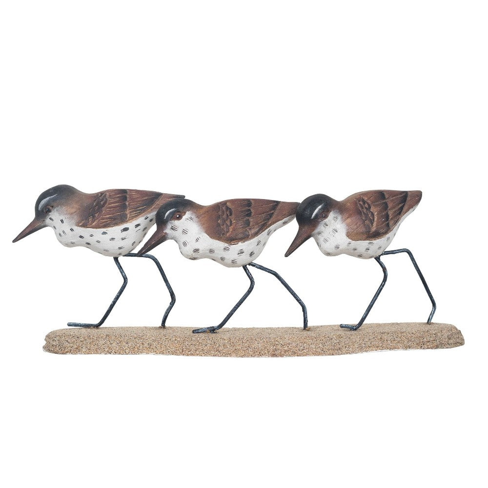 Three decorative bird figures on a sandy base.