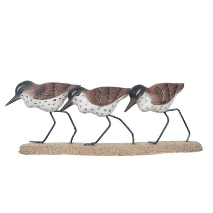 Three decorative bird figures on a sandy base.