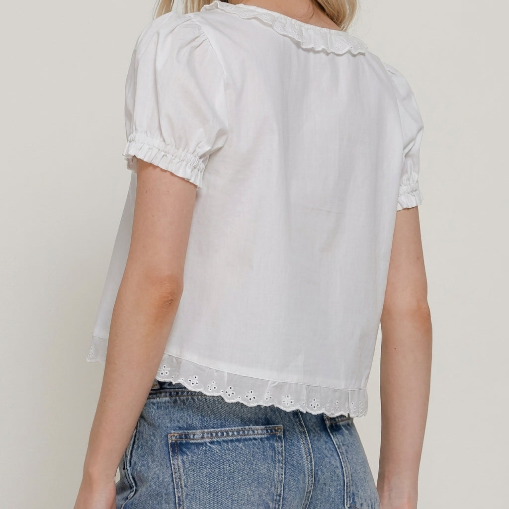 Person wearing a white blouse and denim jeans, back view.
