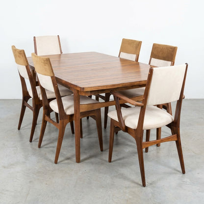 Wooden dining set with beige chairs and decorative tableware centerpiece.