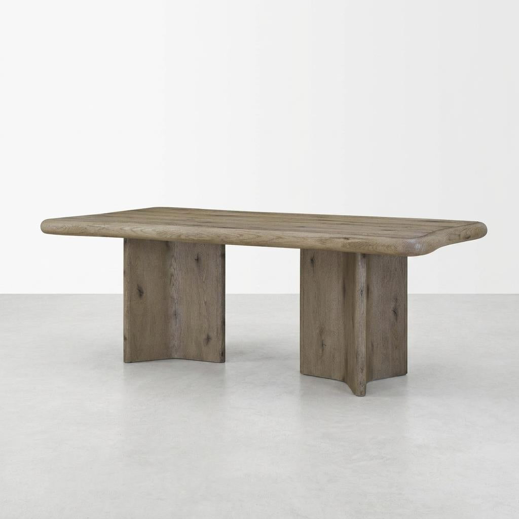 Wooden table with thick legs on a smooth floor.