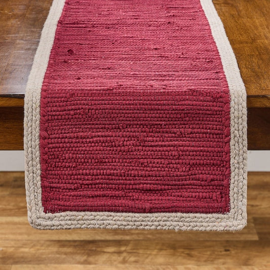 Red table runner with textured fabric and gray border.