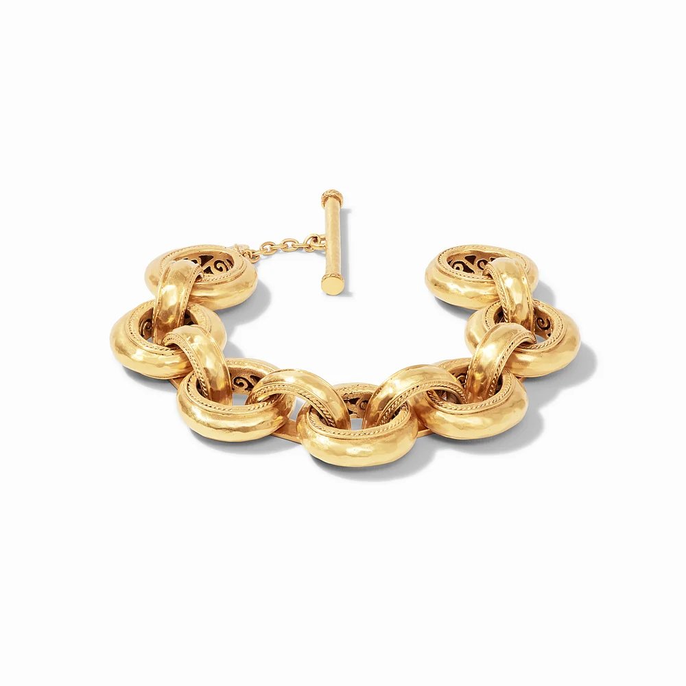 A chunky gold bracelet with interlocking ornate links and a toggle clasp.