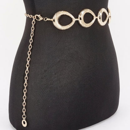 Gold chain belt with circular links on a black mannequin.