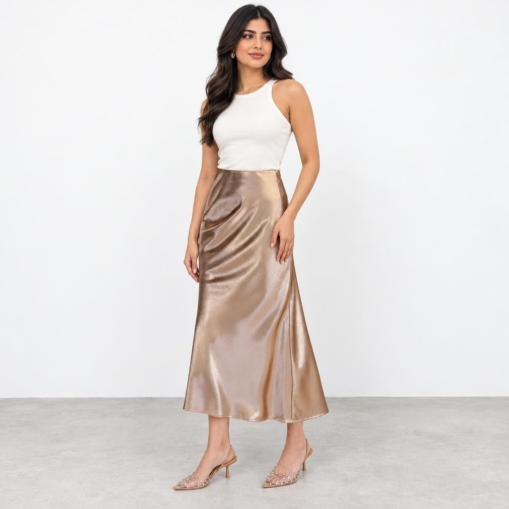 Woman modeling a white sleeveless top, champagne satin midi skirt, and embellished heels.